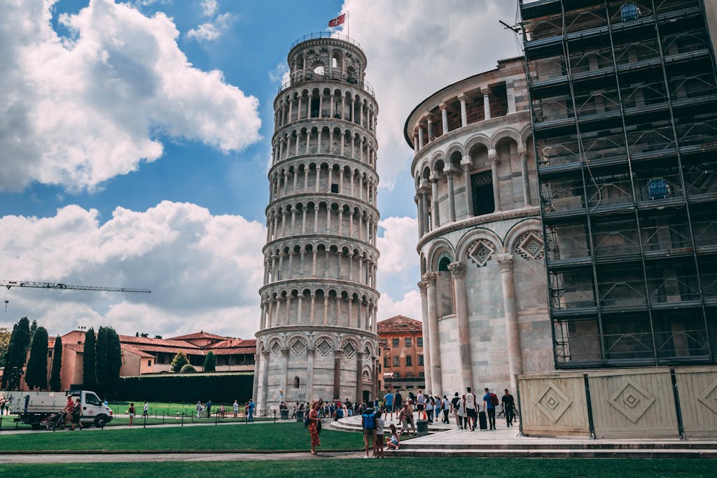 Capture of the iconic Leaning Tower of Pisa and tourists enjoying a sunny day.